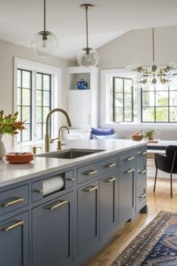 blue kitchen cabinets with brass hardware on kitchen island