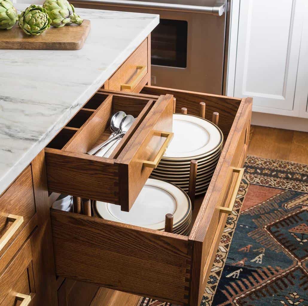 inside of cabinet drawers with cutlery and stacked plates